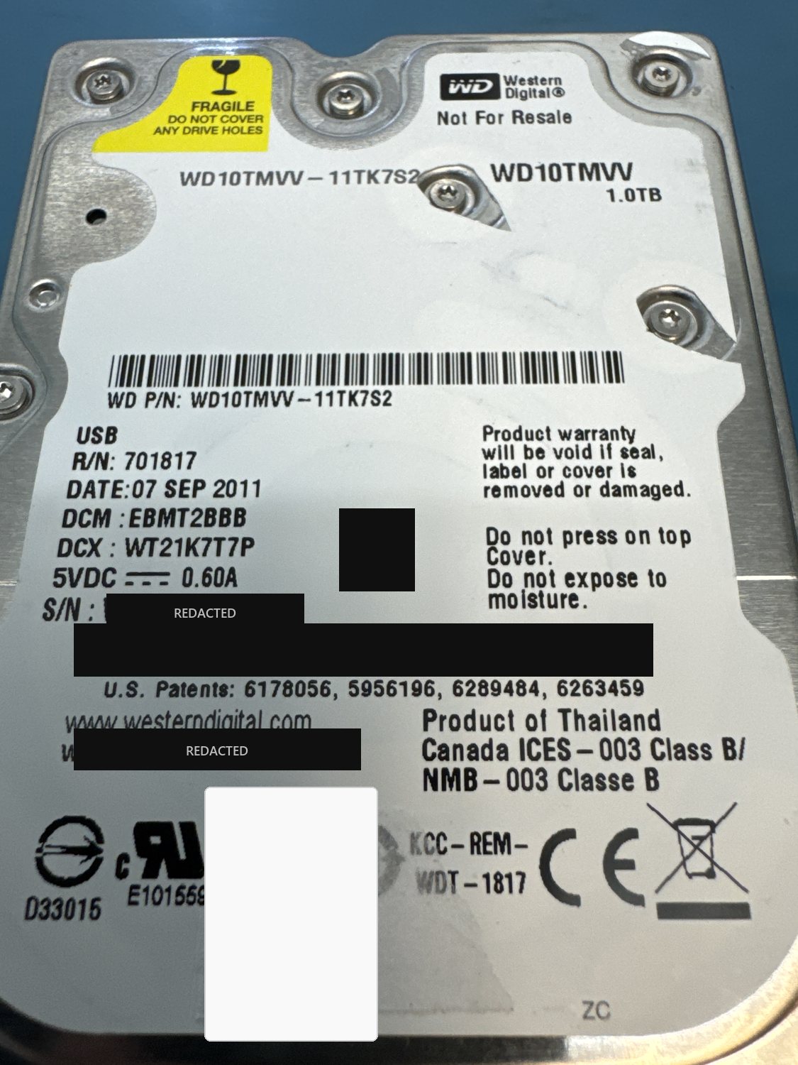 Western Digital WD10TMVV 1 TB USB hard drive label, serial number, WWN and data-matrix code redacted